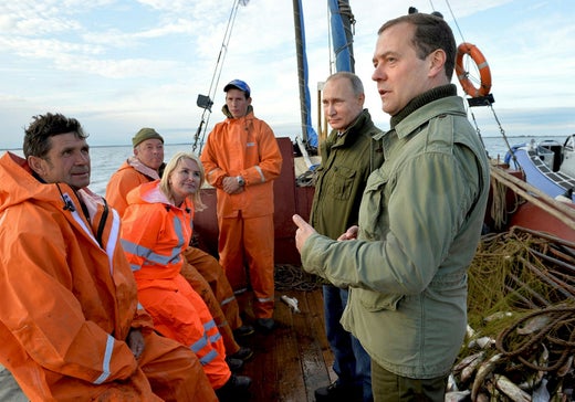 Putin speaks with what is said to be a fisherman on a boat on Lipno Island in Lake Ilmen in the Novgorod region on September 10, 2016. Left, the blonde woman accused of being an extra.